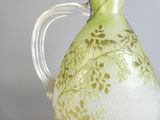 a green and white vase with gold designs on it
