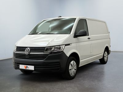 La camionnette blanche est garée dans une grande pièce au sol noir