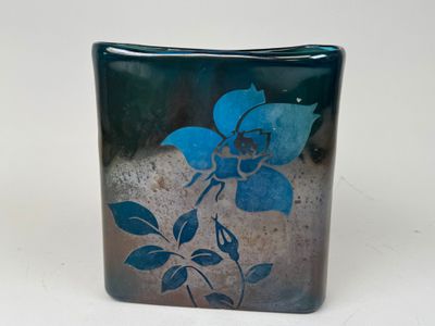 un vase en verre orné d'une fleur bleue