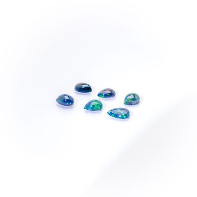 a group of blue and green oplite stones on a white surface