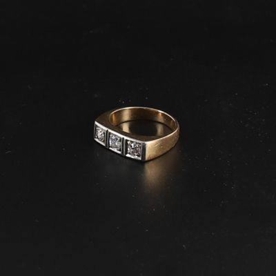 a close up of a gold and diamond ring on a black surface