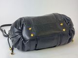 black leather handbag with gold studded handles on a white background