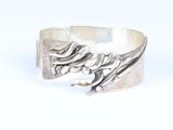 a close up of a silver ring with a bird on it