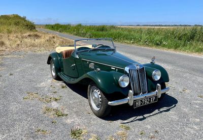 une voiture verte garée sur le bord de la route