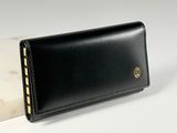 un portefeuille en cuir noir avec un bloc de marbre blanc en arrière-plan