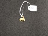 a necklace with a gold elephant on it on a black surface