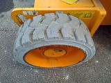 a tire that is sitting on the ground next to a construction vehicle