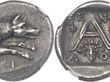 an ancient coin with a dog on it and a letter on the front