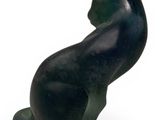 statue of a black cat sitting on its hind legs on a white surface