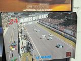 three books on the wall of a building with a picture of a racing car