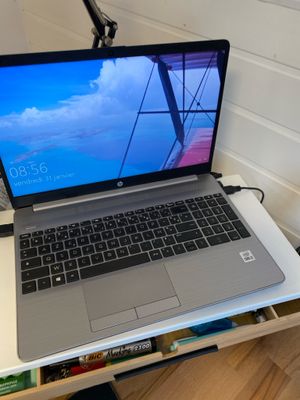 un ordinateur portable posé sur un bureau, à côté d'une lampe