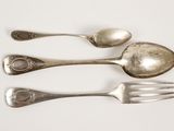 three spoons and a fork on a white surface