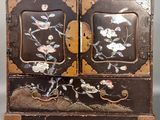 une armoire noire et dorée ornée de fleurs et d'oiseaux peints