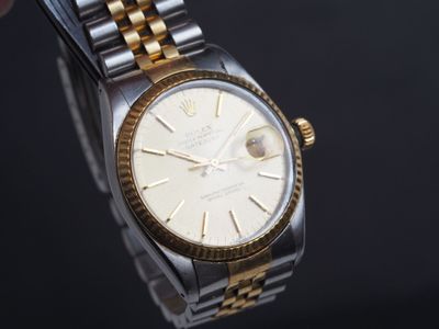 une montre Rolex en or et argent avec un cadran blanc