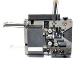 un vieux projecteur de cinéma posé sur une surface blanche