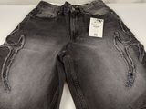 un gros plan sur un short en jean noir sur fond blanc