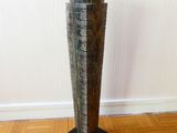 a tall wooden sculpture on a wooden floor in a room