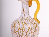 un vase blanc et doré avec une anse jaune
