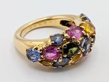 an image of a gold ring with multi colored stones on it