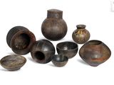 many different types of vases and bowls on a white surface