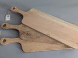 two wooden cutting boards sitting next to each other on top of a table