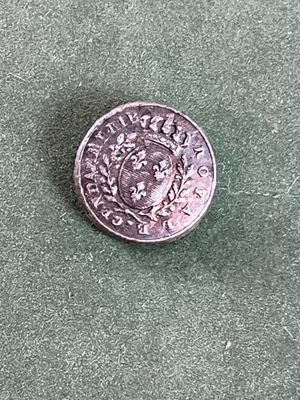 une vieille pièce d'argent posée sur une surface verte