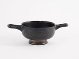 an image of a small black bowl with handles on a white surface