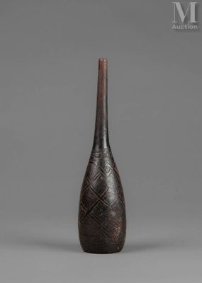 a black vase sitting on top of a table next to a gray wall