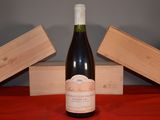a bottle of wine sitting on a table next to two wooden boxes