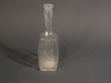 une bouteille en verre transparent contenant un peu de sable