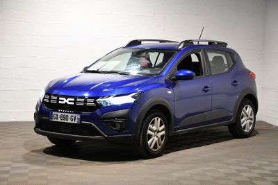 La voiture bleue est garée dans une pièce dont le sol est en damier.