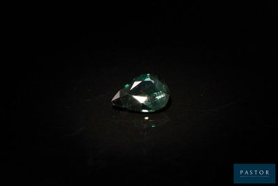 gros plan d'un diamant vert sur une surface noire