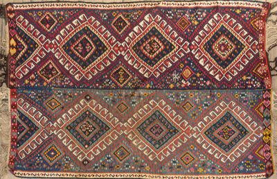 a close up of a colorful rug on a stone surface