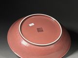 a red bowl with a white rim sitting on a table