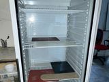 an empty refrigerator in the middle of a room