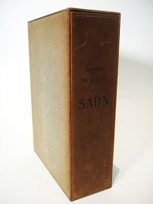 an old book sitting on top of a table on a white surface