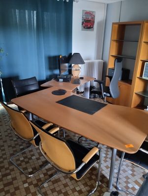 tables and chairs in a room with a bookcase and a lamp
