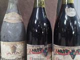 three bottles of wine are lined up on a shelf