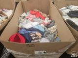 deux cartons remplis de vêtements posés par terre