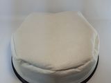 a white cake sitting on a white surface with a black band