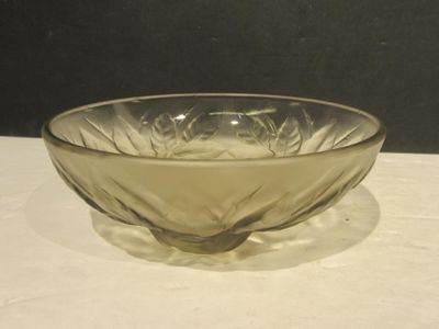a glass bowl sitting on a table with a black background