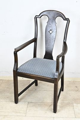 une chaise en bois avec une assise bleue posée sur un sol carrelé