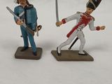 two toy soldiers are standing in the snow with swords