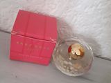 pink box of perfume sitting on a table next to a pink box of perfume