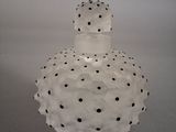 un vase blanc orné de pois noirs