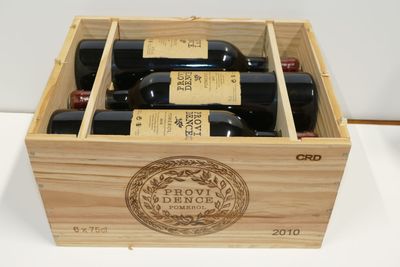 quatre bouteilles de vin dans un coffret en bois posé sur une table