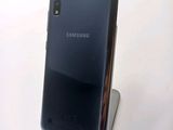 the back of a black samsung phone sitting on top of a metal stand