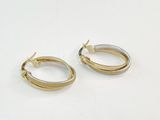 two tone gold and silver hoop earrings on a white surface