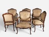 six antique chairs with upholstered arms and a carved back