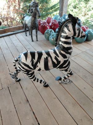 a statue of a zebra and a horse on a porch